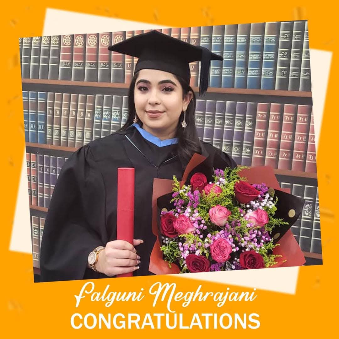 Falguni Meghrajani in cap and gown at her graduation, holding flowers and her diploma
